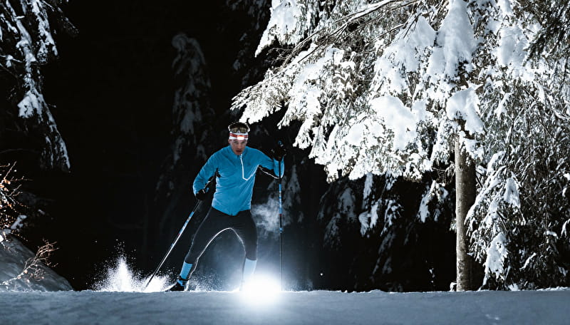 Skieur abordant un virage sur une piste de ski nordique ouverte en nocturne au Grand-Bornand